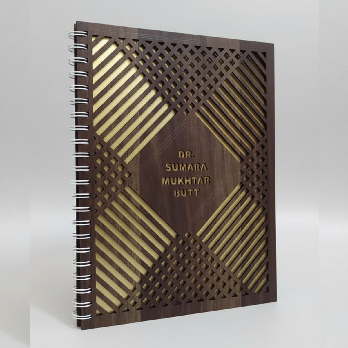 Wooden notebook with geometric design and engraved text on a white background